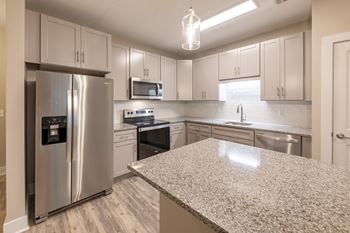 A kitchen with a granite countertop and stainless steel appliances at Foxwood Apartments, Raleigh-Durham